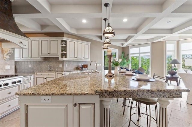 21211 E 34th St S, Independence, MO 64057 - kitchen with coffered ceiling, stainless steel gas stovetop, a breakfast bar area, decorative backsplash, and a large island with sink
