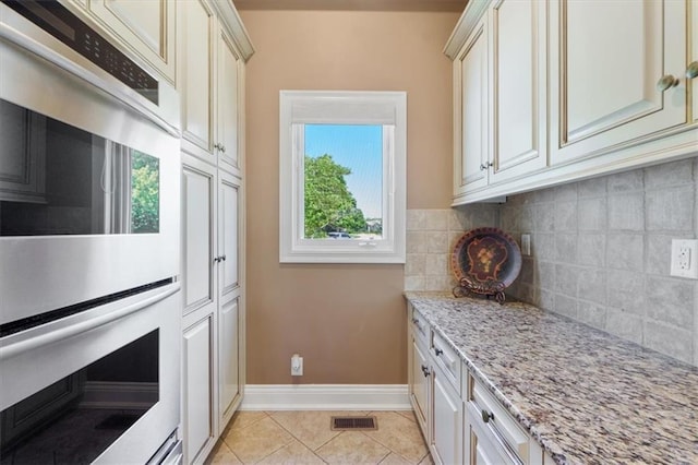 21211 E 34th St S, Independence, MO 64057 - kitchen with double oven, decorative backsplash, light stone counters, and light tile patterned floors