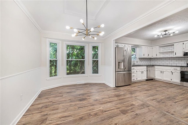1917 N Concord Rd, Independence, MO 64058 - kitchen with appliances with stainless steel finishes, dark countertops, plenty of natural light, a chandelier, and ornamental molding