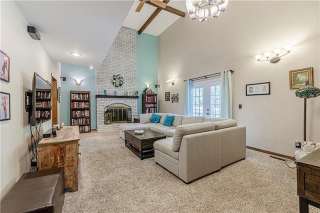 living room with carpet floors, high vaulted ceiling, a brick fireplace, baseboards, and a chandelier