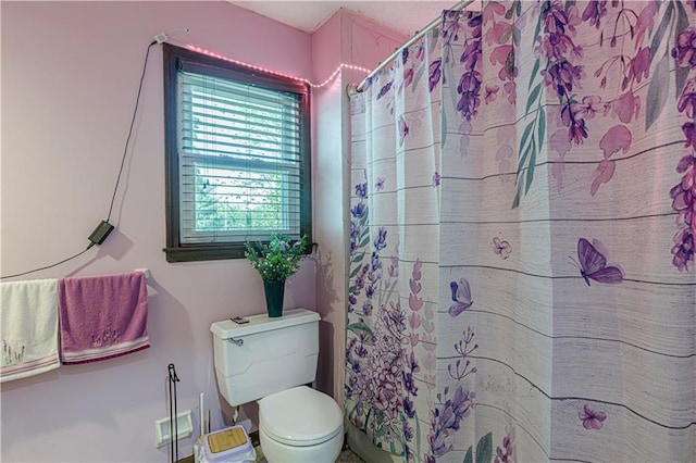 full bath featuring toilet and a shower with curtain