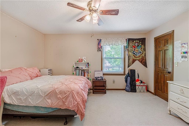 bedroom featuring a textured ceiling, light carpet, ceiling fan, and baseboards