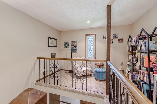 stairs featuring a textured ceiling and recessed lighting