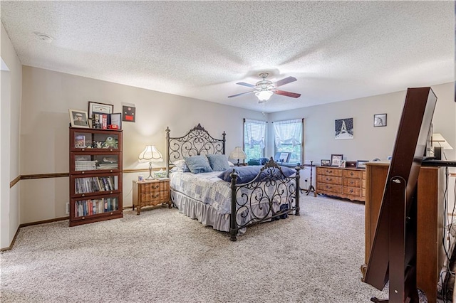 carpeted bedroom with a textured ceiling and a ceiling fan