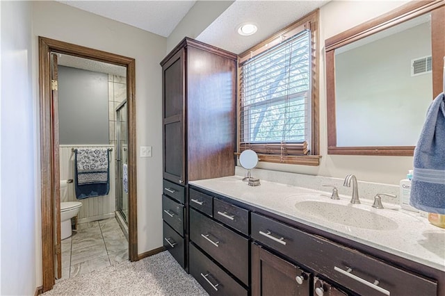 full bathroom with toilet, vanity, a stall shower, marble look tile flooring, and baseboards