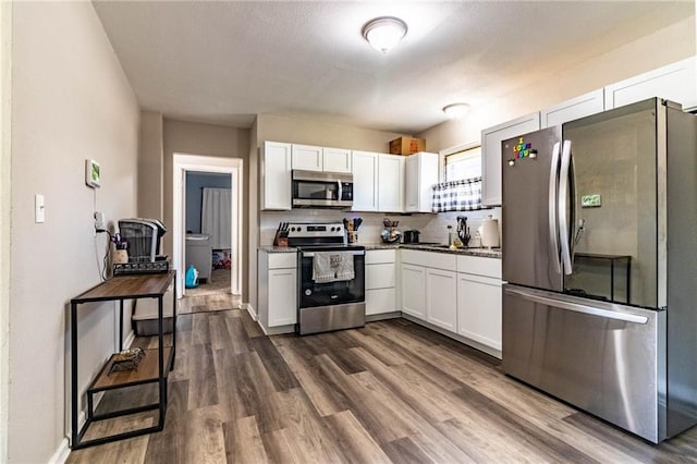 1007 Vest Dr, Warrensburg, MO 64093 - kitchen featuring stainless steel appliances, white cabinets, dark wood-style floors, and backsplash