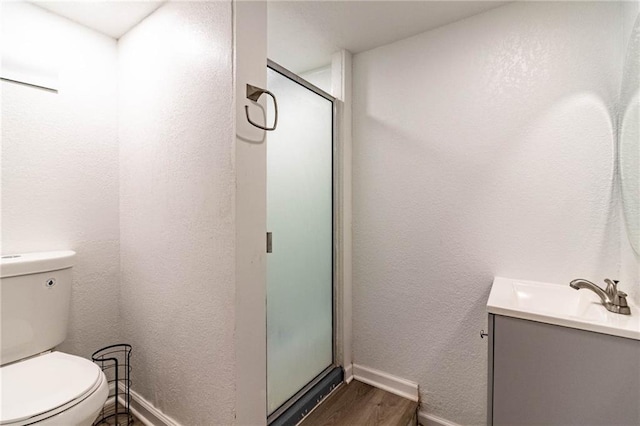 1007 Vest Dr, Warrensburg, MO 64093 - bathroom with wood finished floors, baseboards, a stall shower, vanity, and toilet