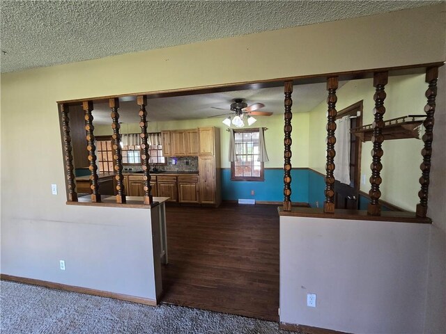 kitchen with ceiling fan, baseboards, a textured ceiling, and dark wood-type flooring
