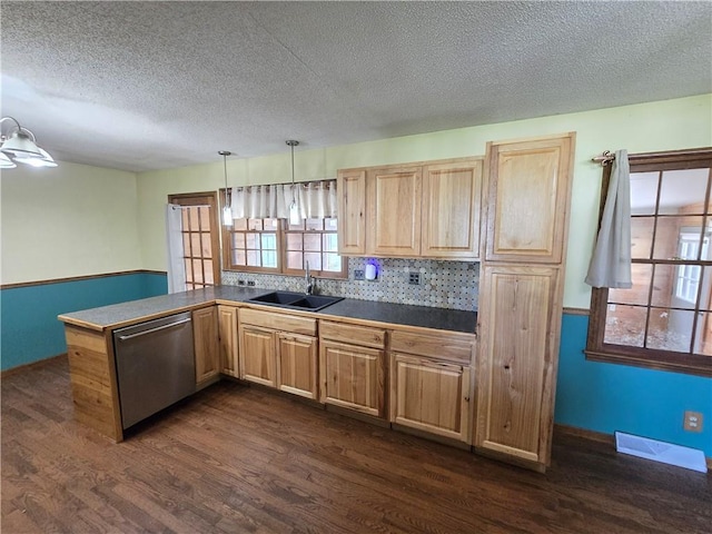 kitchen featuring stainless steel dishwasher, a sink, dark wood-style flooring, light brown cabinetry, and a textured ceiling