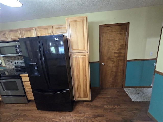 kitchen featuring appliances with stainless steel finishes, light brown cabinets, dark wood-type flooring, and a textured ceiling