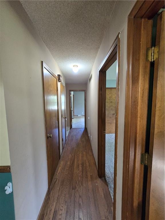 hallway featuring a textured ceiling and wood finished floors