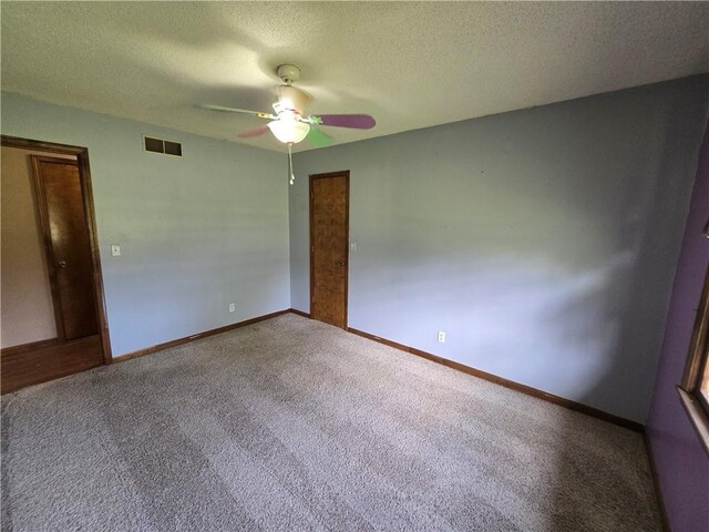 carpeted empty room featuring a ceiling fan, a textured ceiling, and baseboards