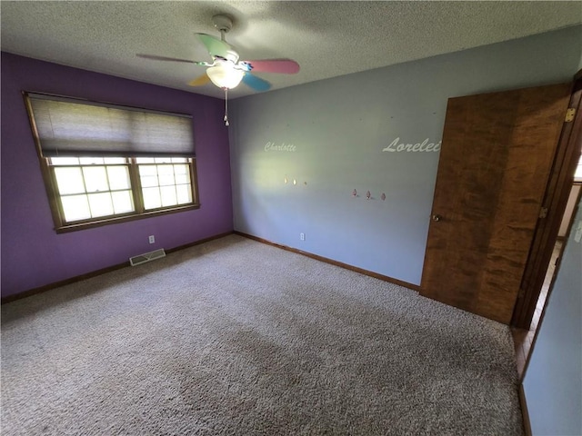 spare room featuring a ceiling fan, carpet flooring, a textured ceiling, and baseboards