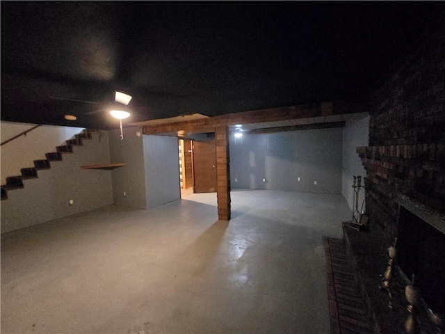 finished basement featuring stairs and a fireplace