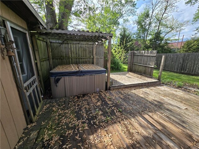 wooden deck with a hot tub and fence