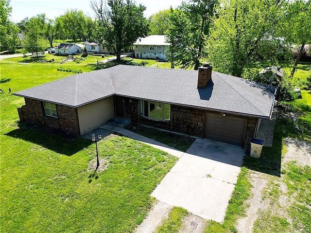 ranch-style home with concrete driveway, a garage, a chimney, a front yard, and a shingled roof