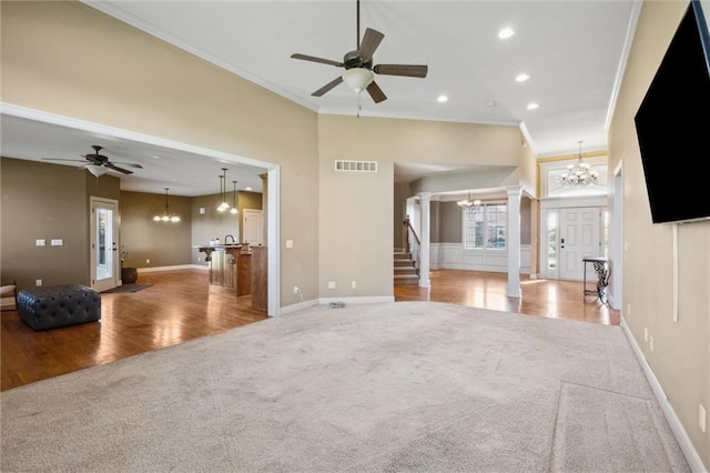unfurnished living room with a chandelier, carpet floors, crown molding, a ceiling fan, and recessed lighting