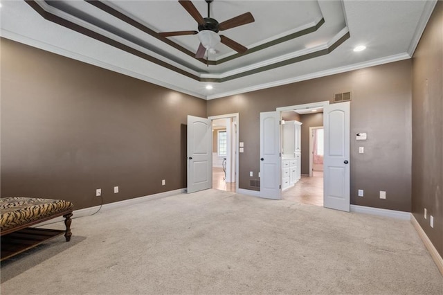 unfurnished bedroom featuring light carpet, connected bathroom, ornamental molding, baseboards, and a tray ceiling
