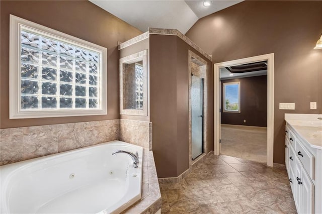bathroom with vanity, a shower stall, a tub with jets, and baseboards