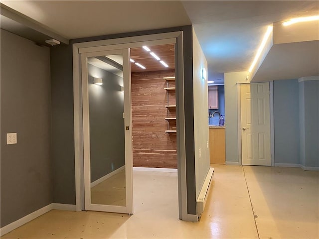 220 N 9th St, Atchison, KS 66002 - corridor with wood walls, a sink, baseboards, baseboard heating, and concrete floors