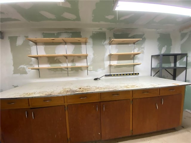 220 N 9th St, Atchison, KS 66002 - kitchen featuring open shelves, brown cabinetry, and light stone counters