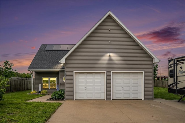 19204 E 15th Terrace Ct N, Independence, MO 64056 - view of front of home with roof mounted solar panels, driveway, and roof with shingles