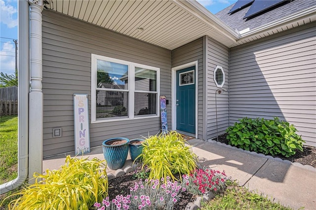 19204 E 15th Terrace Ct N, Independence, MO 64056 - doorway to property with roof mounted solar panels and a shingled roof