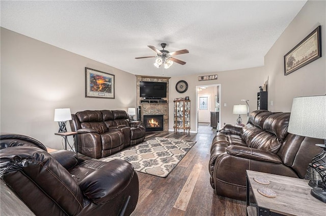 19204 E 15th Terrace Ct N, Independence, MO 64056 - living room with wood finished floors, a ceiling fan, a fireplace, and a textured ceiling
