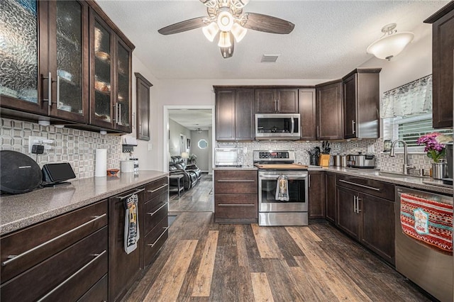 19204 E 15th Terrace Ct N, Independence, MO 64056 - kitchen with stainless steel appliances, dark brown cabinetry, ceiling fan, dark wood finished floors, and decorative backsplash