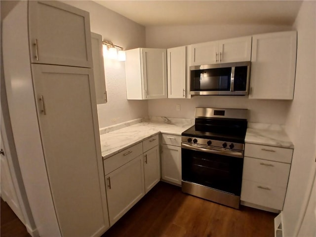 1029 Shearer Rd, Kansas City, KS 66103 - kitchen with appliances with stainless steel finishes, dark wood finished floors, white cabinets, and light stone countertops