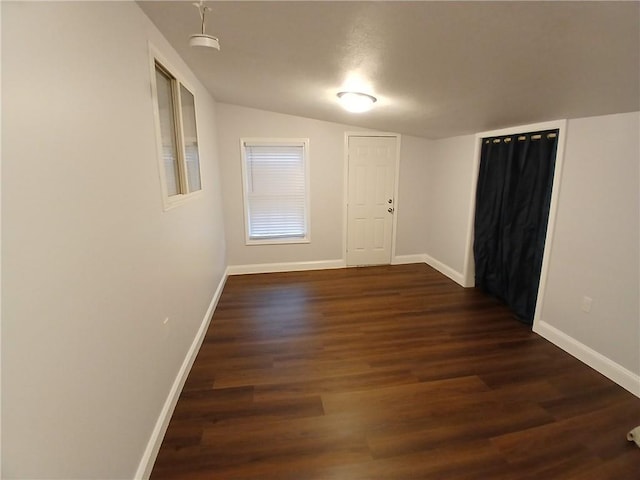 1029 Shearer Rd, Kansas City, KS 66103 - unfurnished room featuring lofted ceiling, baseboards, and dark wood-type flooring