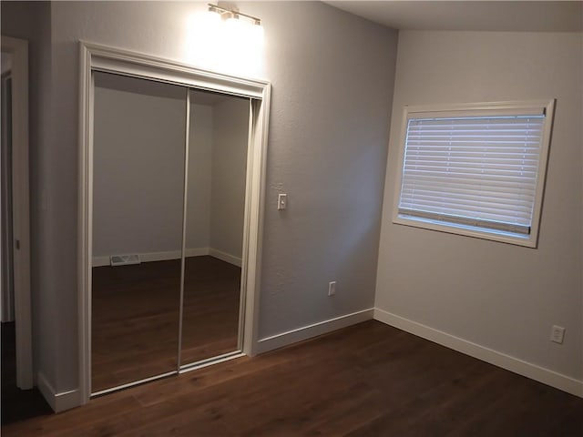 1029 Shearer Rd, Kansas City, KS 66103 - unfurnished bedroom with dark wood-style floors, a closet, and baseboards