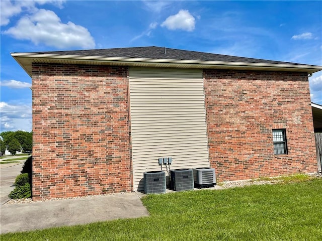 596 SE 105th Rd, Warrensburg, MO 64093 - view of side of property featuring central AC unit, brick siding, and a lawn