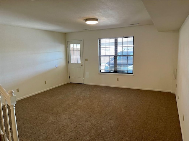 596 SE 105th Rd, Warrensburg, MO 64093 - empty room featuring dark carpet, baseboards, and stairs