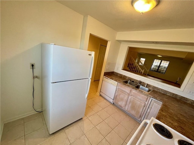 596 SE 105th Rd, Warrensburg, MO 64093 - kitchen featuring white appliances, a sink, light tile patterned floors, dark countertops, and baseboards