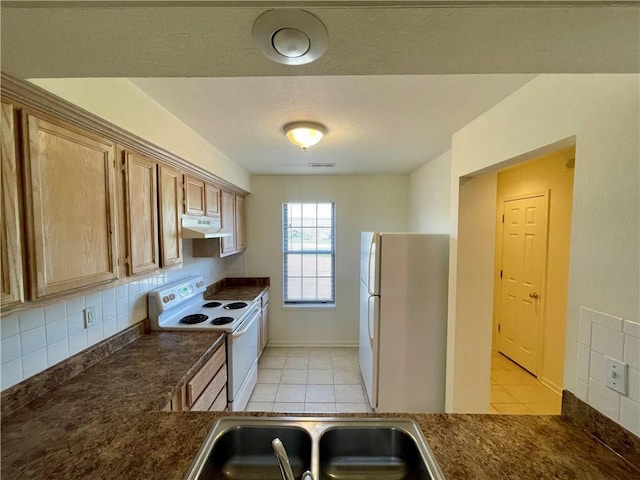596 SE 105th Rd, Warrensburg, MO 64093 - kitchen with white appliances, a sink, dark countertops, under cabinet range hood, and light tile patterned floors