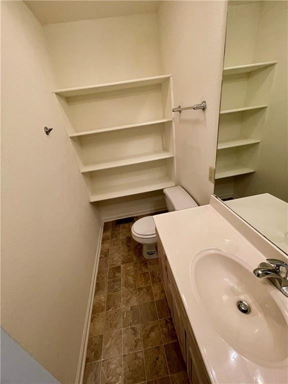 596 SE 105th Rd, Warrensburg, MO 64093 - bathroom featuring toilet, baseboards, and vanity