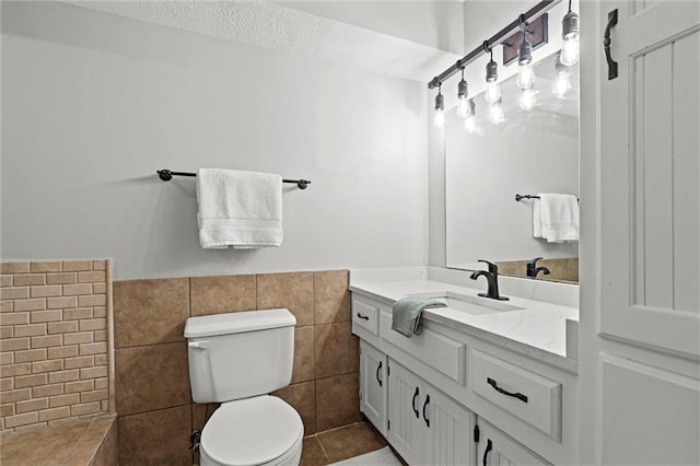 1036 NE Remington Ct, Lees Summit, MO 64086 - bathroom featuring toilet, tile walls, wainscoting, vanity, and tile patterned flooring