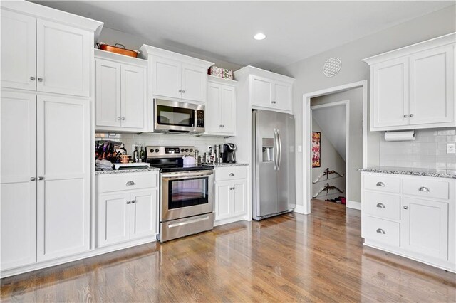 25201 W 149th Ter, Olathe, KS 66061 - kitchen featuring stainless steel appliances, decorative backsplash, white cabinetry, wood finished floors, and recessed lighting