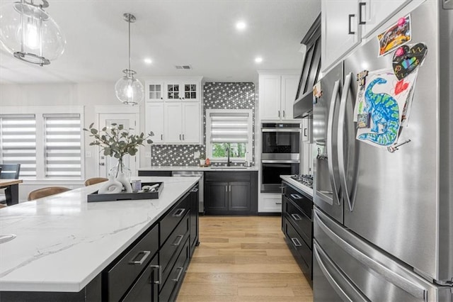 546 N Oakwood Ln, Tonganoxie, KS 66086 - kitchen with appliances with stainless steel finishes, a sink, dark cabinetry, white cabinetry, and light wood-style floors