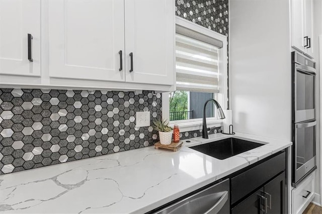 546 N Oakwood Ln, Tonganoxie, KS 66086 - kitchen featuring a sink, double oven, white cabinets, decorative backsplash, and light stone counters