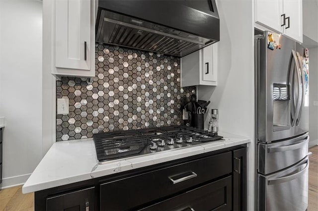 546 N Oakwood Ln, Tonganoxie, KS 66086 - kitchen with range hood, appliances with stainless steel finishes, white cabinetry, backsplash, and light stone countertops