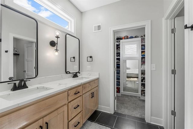 546 N Oakwood Ln, Tonganoxie, KS 66086 - bathroom with a walk in closet, tile patterned flooring, double vanity, and baseboards