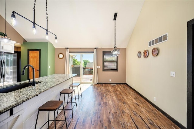 7277 SW Karen Rd, Trimble, MO 64492 - kitchen featuring a sink, lofted ceiling, freestanding refrigerator, dark wood-style floors, and a kitchen breakfast bar