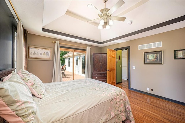 7277 SW Karen Rd, Trimble, MO 64492 - bedroom with a tray ceiling, access to exterior, baseboards, wood finished floors, and a ceiling fan