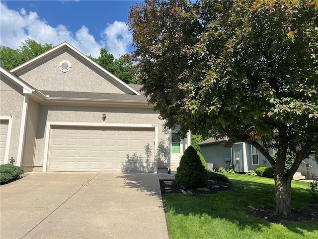 2017 S 137th St, Bonner Springs, KS 66012 - view of front of house with concrete driveway, an attached garage, a front yard, and stucco siding