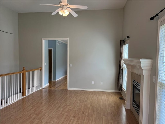 2017 S 137th St, Bonner Springs, KS 66012 - unfurnished living room with a ceiling fan, wood finished floors, high vaulted ceiling, baseboards, and a glass covered fireplace
