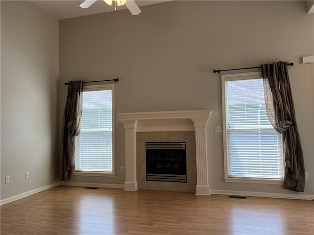 2017 S 137th St, Bonner Springs, KS 66012 - unfurnished living room with wood finished floors, ceiling fan, baseboards, a fireplace, and healthy amount of natural light