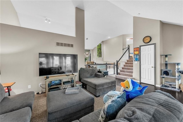 living room with stairway, high vaulted ceiling, and baseboards