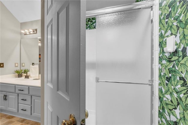 full bathroom featuring a shower with shower door, vanity, and wood finished floors
